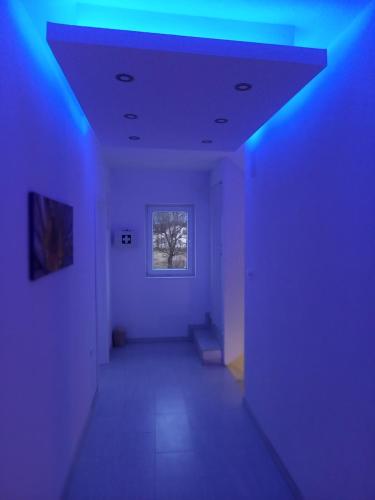 an empty hallway with blue lights in a room at Premier House by RD Group in Korenica