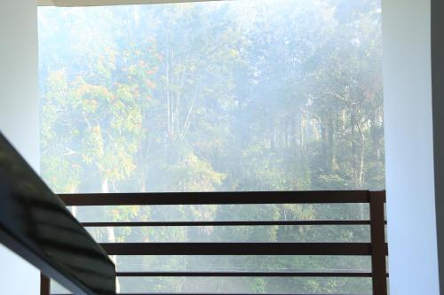 a window with a view of a forest at Aditi in Thekkady