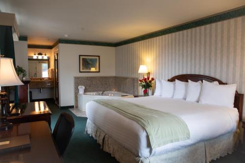 a hotel room with a bed and a bath tub at Emerald Dolphin Inn & Mini Golf in Fort Bragg