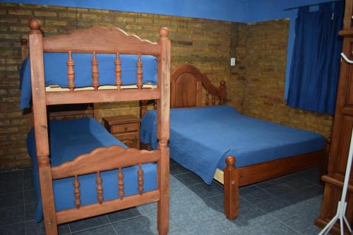 a bedroom with two bunk beds with blue sheets at Postal Sur in Río Colorado