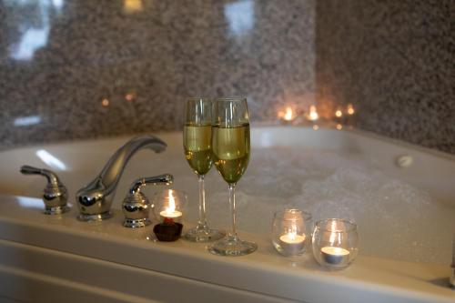 布拉格堡的住宿－翡翠海豚酒店及迷你高爾夫，浴缸里放两杯葡萄酒和蜡烛