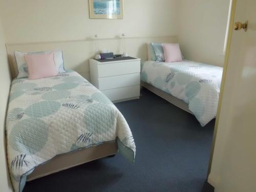 a bedroom with two beds and a dresser in it at Glenelg Sea-Breeze in Adelaide