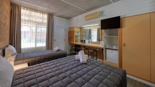 a hotel room with two beds and a kitchen at Goondiwindi Motel in Goondiwindi
