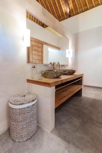a bathroom with two sinks and a trash can at Villa Lempuyangdream in Karangasem