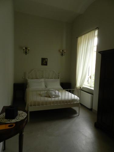 a bedroom with a white bed and a window at Relais Real Collegio in Noli