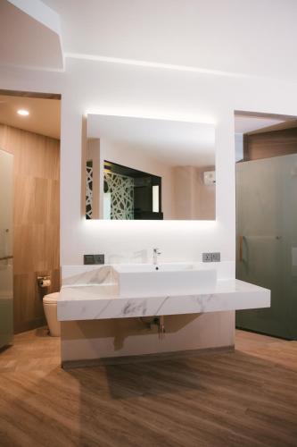 a bathroom with a white sink and a mirror at 56 Hotel in Bangna