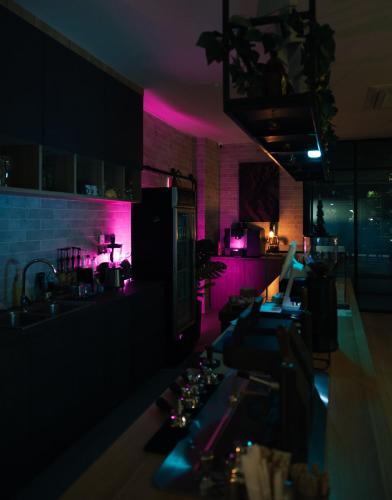 a kitchen with purple lighting and a counter in a room at 56 Hotel in Bangna