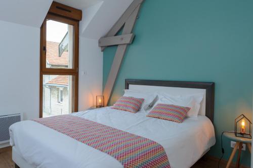 - une chambre avec un lit blanc avec deux oreillers et une fenêtre dans l'établissement La Ferme de Wary, à Brimont