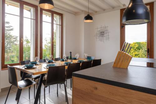 une salle à manger avec une table, des chaises et des fenêtres dans l'établissement La Ferme de Wary, à Brimont