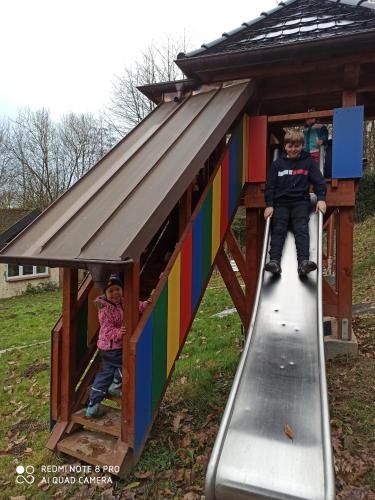 a boy and a girl on a slide in a play house at Pension Waldsauna in Arnsberg