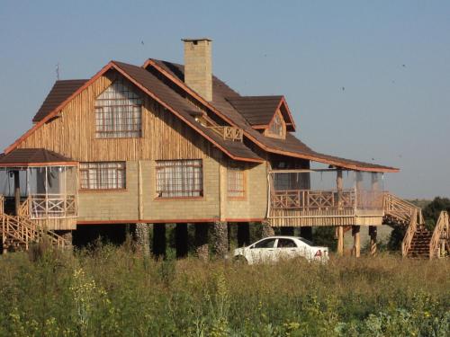 a house with a car parked in front of it at Sangare Gardens- Book Now Enjoy Free Farm Tour in Mweiga