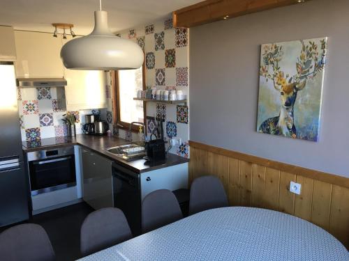 une petite cuisine avec une table et des chaises. dans l'établissement Chalet Reymond Pre du lac, à Tignes