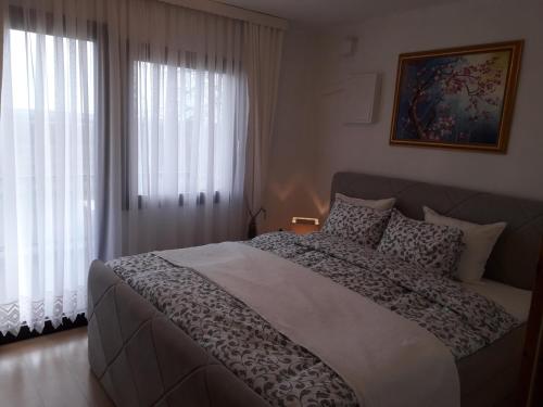 Un dormitorio con una cama grande y una ventana en Ferienhaus Weingarten Eisenberg en Vaskeresztes