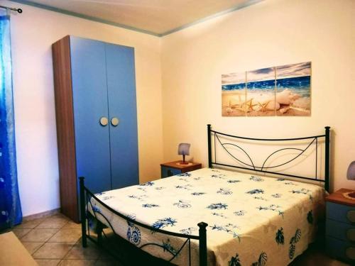 a bedroom with a bed and a blue cabinet at Casa Isulidda in San Vito lo Capo