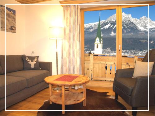 a living room with a couch and a table at KAISERapart ELLMAU Zentrum in Ellmau