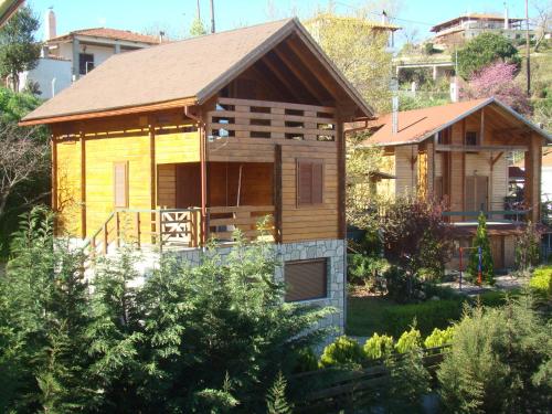 a small wooden house in the middle of a garden at Zeus-Village οικισμός φινλανδικών chalet με πισίνες & γυμναστήριο in Mólos