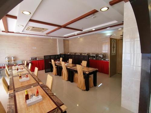 a restaurant with wooden tables and chairs in a room at Nizwa Hotel Apartments in Nizwa