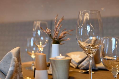 a table with wine glasses and a candle on it at Gasthof-Pension Wulfenia in Gargellen