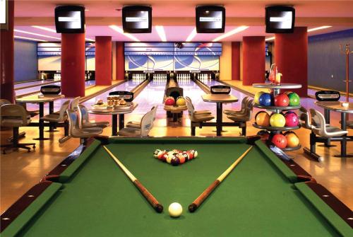 a billiard room with a pool table and bowling lanes at Signia by Hilton in Amman