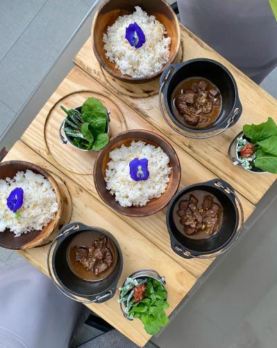 a wooden tray with bowls of rice and mushrooms at Jony's Beach Resort in Boracay