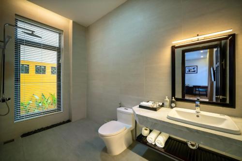 uma casa de banho com um WC, um lavatório e uma janela em Serene River Hoian em Hoi An