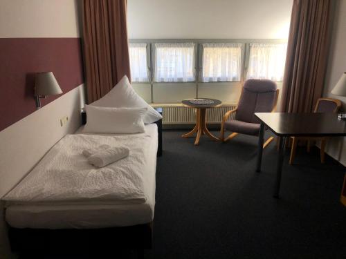 een hotelkamer met een bed en een tafel en stoelen bij Apartment 31 in Sindelfingen