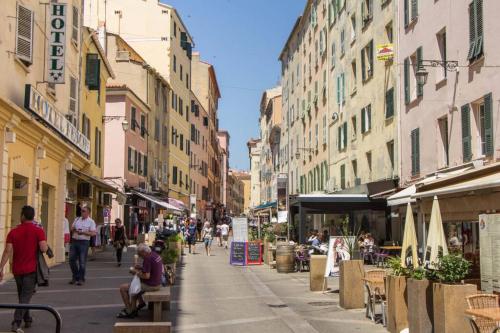 Eine Straße mit Leuten, die eine Straße mit Gebäuden entlang laufen in der Unterkunft T2 type new yorkais in Ajaccio