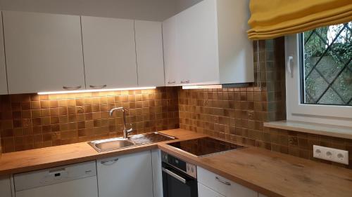 a kitchen with white cabinets and a sink and a window at Ferienwohnung Floriani in St. Wolfgang