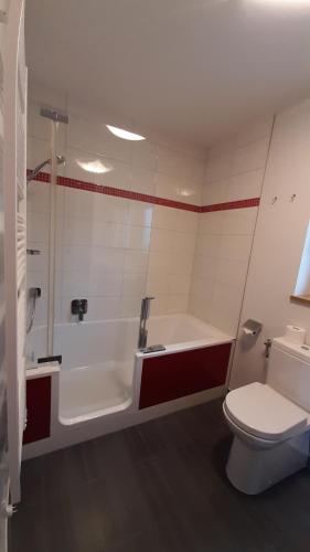 a bathroom with a tub and a toilet and a sink at Ferienwohnung Floriani in St. Wolfgang