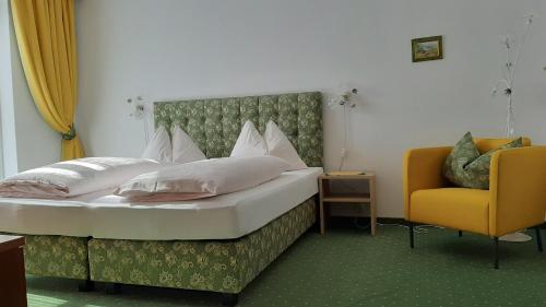 a bedroom with a bed and a yellow chair at Ferienwohnung Floriani in St. Wolfgang