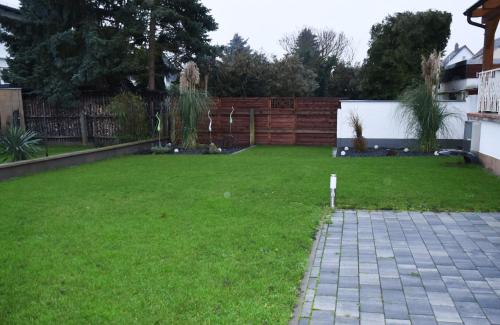 a yard with a fence and a green lawn at Pension Nickel Ferienwohnung I Waldstraße 18 Alsbach-Hähnlein in Alsbach-Hähnlein