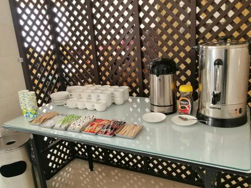 a table with a coffee maker and cups on it at Nizwa Hotel Apartments in Nizwa