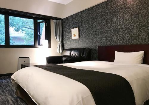 熊本市にあるホテル　オークスのベッドルーム(大型ベッド1台、革張りのソファ付)
