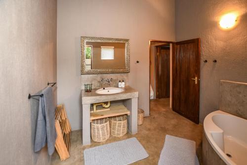 Un baño con lavabo, espejo e inodoro. en Khiza Bush Retreat, en Hoedspruit