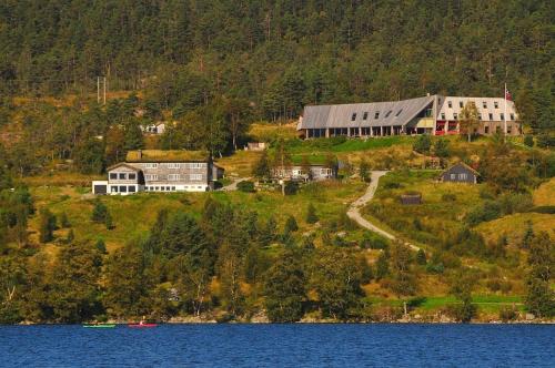a large house on a hill next to a lake at Hikers Camp, Part of Preikestolen BaseCamp in Jørpeland