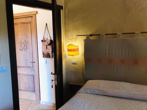a bedroom with a bed and an open door at Il Nuraghe del lago Coghinas in Oschiri