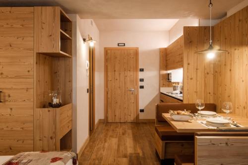 una cucina con pareti in legno e un tavolo con bicchieri da vino di Chalet Bellavista a Livigno