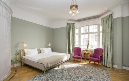 a bedroom with a bed and two purple chairs at Hotel Esplanade, BW Signature Collection in Stockholm