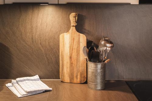a container of utensils on a counter with a bottle at An der Via Claudia Augusta in Fiss