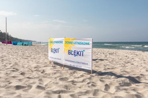 a sign in the sand on a beach at Domki Letniskowe Błękit in Jastrzębia Góra