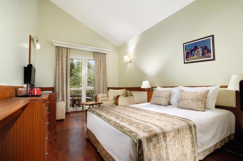 een hotelkamer met een groot bed en een bureau bij Belcekiz Beach Club - All Inclusive in Oludeniz