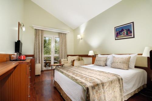 a hotel room with a large bed and a desk at Belcekiz Beach Club - All Inclusive in Oludeniz