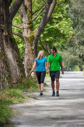 a man and a woman walking down a road at Hotel Stadt Wien in Zell am See