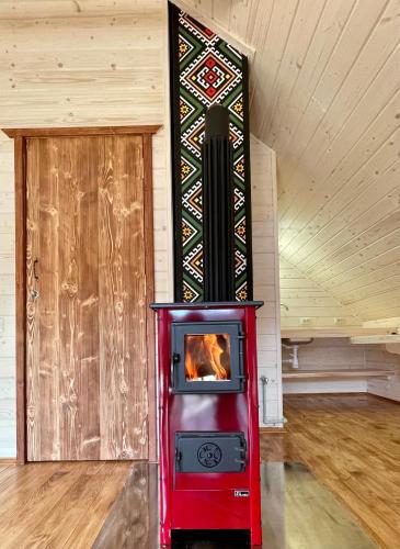 a wood stove in a room with a door at Chalet PidStromom in Mykulychyn
