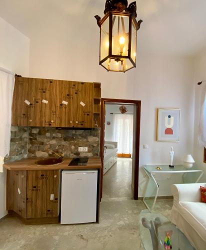a kitchen with wooden cabinets and a chandelier at Lion House I in Ioulida