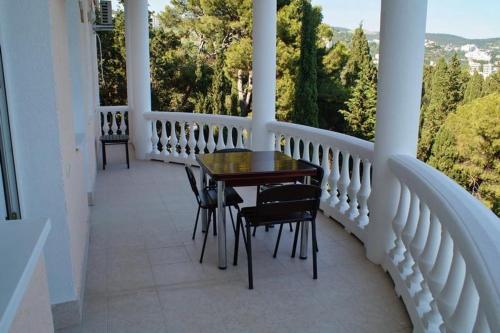 a porch with a table and chairs on a balcony at Gloria Park Hotel in Koreiz