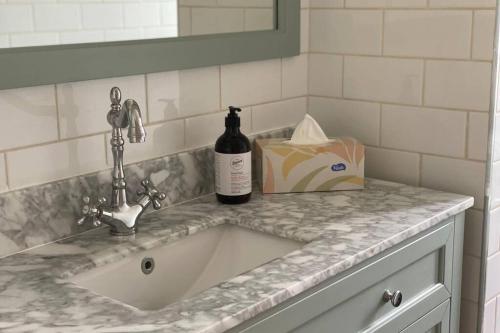 a sink with a bottle of wine on a counter at Coochin Cottage, Beerwah in Beerwah