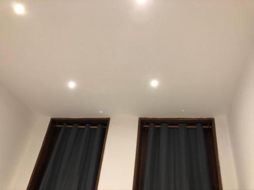 une pièce avec deux rideaux et deux lumières au plafond dans l'établissement The place to be, à Roubaix