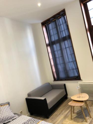 une chambre avec un canapé, une table et une fenêtre dans l'établissement The place to be, à Roubaix