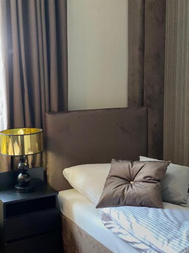 a bed with a pillow and a lamp on a table at Family & Business Sauna Apartments Klonowa nad Zalewem, Unikat SPA - 2 Bedroom with Private Sauna, Jacuzzi, Air Conditioning, Garage - The Highest Standard! in Kielce